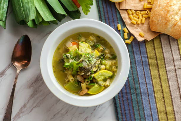 Un bol appétissant de soupe au pistou, garni de légumes frais et de basilic haché, présenté sur une élégante table en marbre
