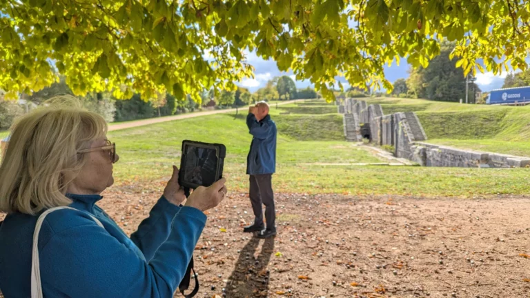 Une participante découvre la reconstitution 3D sur tablette devant l’échelle des Sept-Écluses
